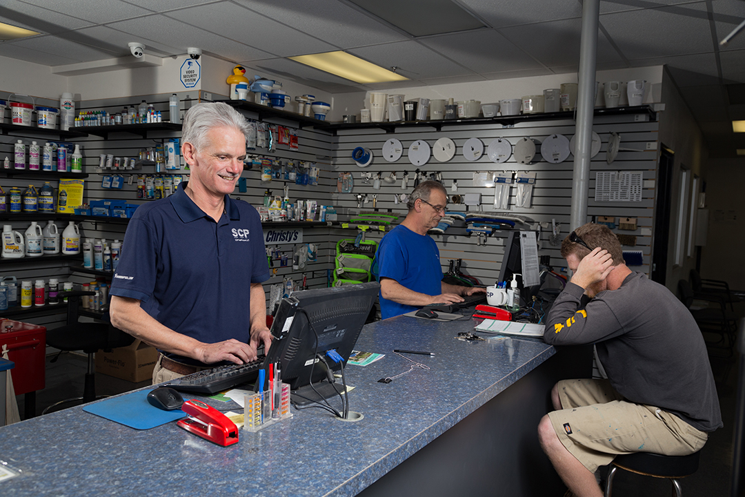 POOLCORP empoloyee working at a counter