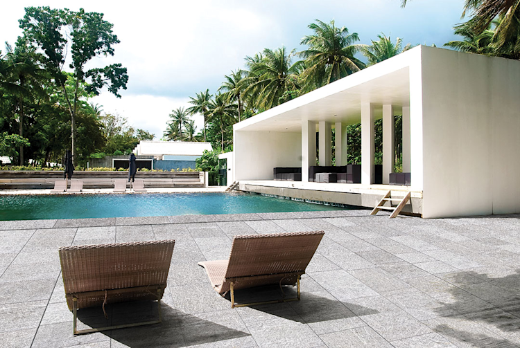 A large swimming pool is surrounded by a wooden deck