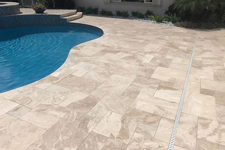 A large swimming pool is surrounded by a wooden deck
