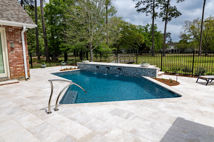 A large swimming pool is surrounded by a wooden deck