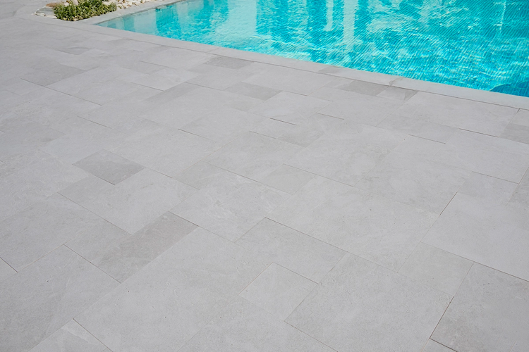 A large swimming pool is surrounded by a wooden deck