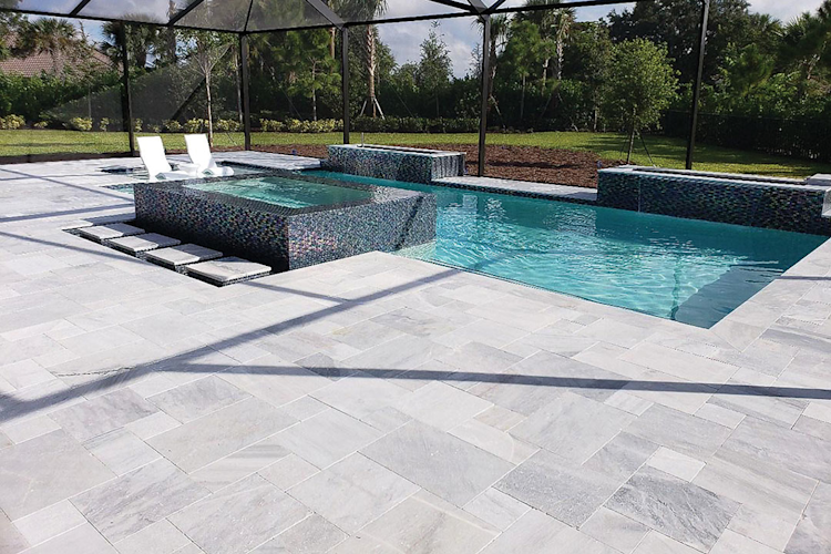 A large swimming pool is surrounded by a wooden deck