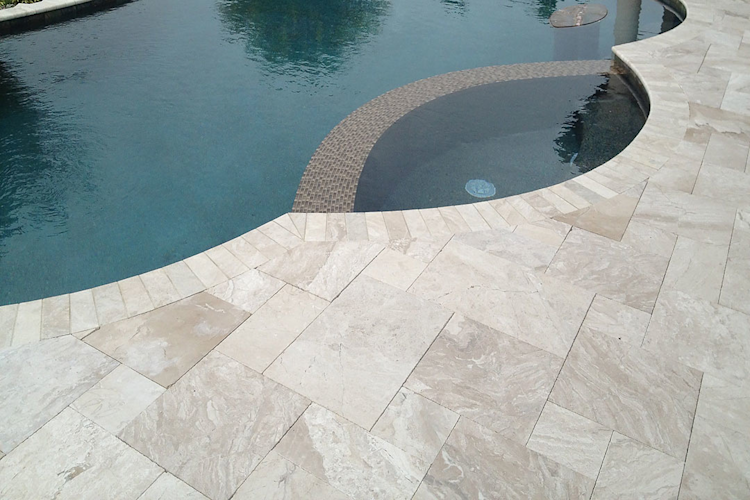 A large swimming pool is surrounded by a wooden deck