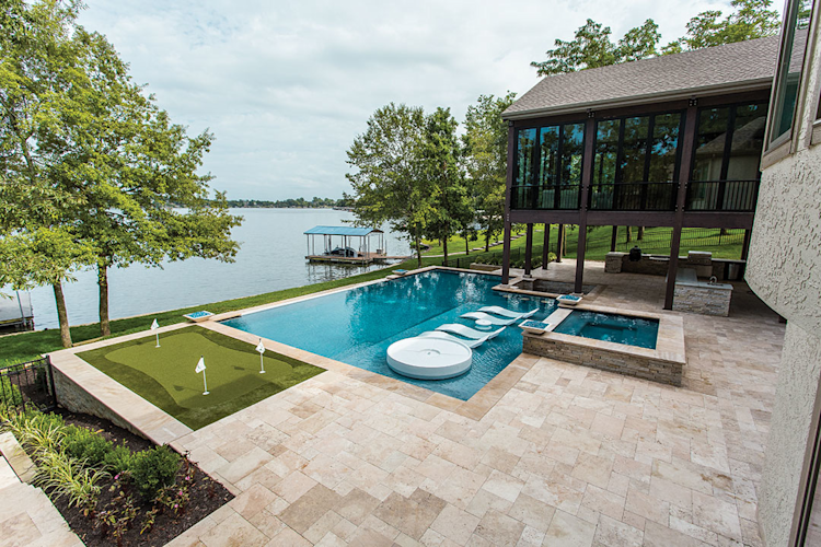 A large swimming pool is surrounded by a wooden deck