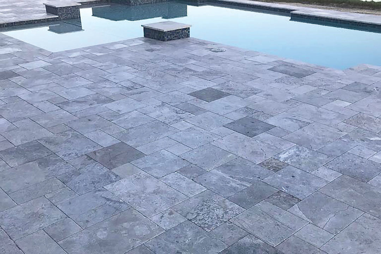 A large swimming pool is surrounded by a wooden deck