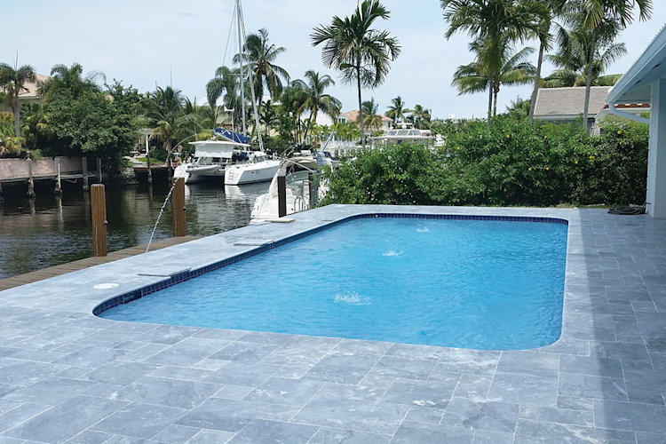 A large swimming pool is surrounded by a wooden deck