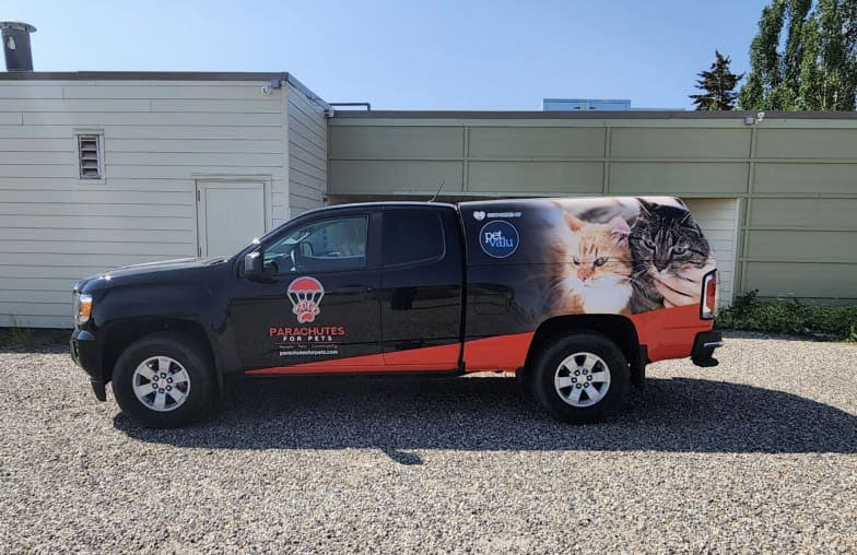 A truck with Parachutes for Pets and Pet Valu branding sit in a driveway