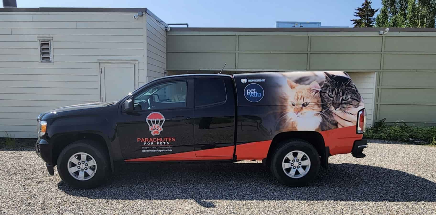 A truck with Parachutes for Pets and Pet Valu branding sit in a driveway