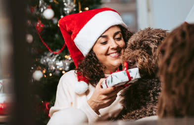 a woman sitting beside her dog and showing a gift