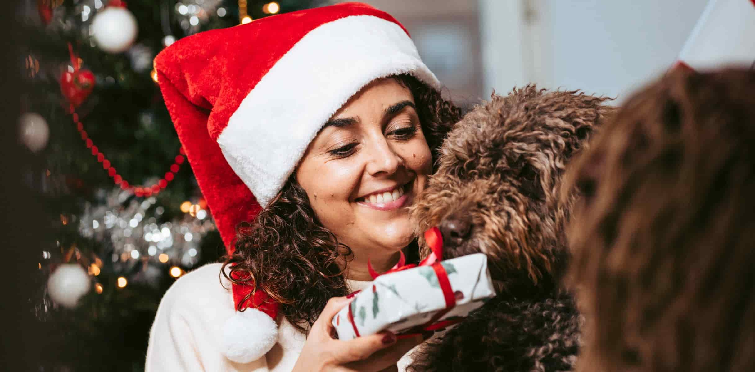 a woman sitting beside her dog and showing a gift