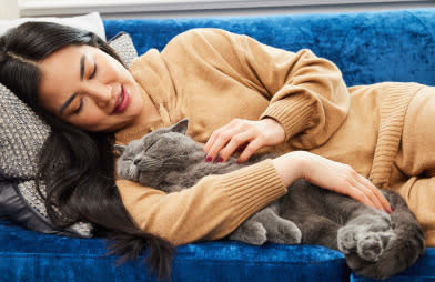 Prevention is the best medicine for a healthy pet (and a healthy wallet) - Woman resting on couch with her cat