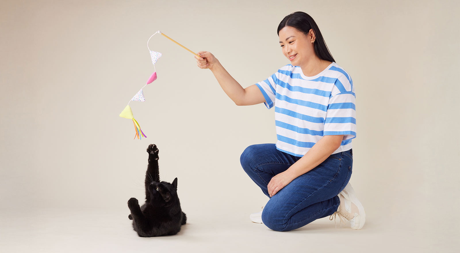 Woman playing with a black cat