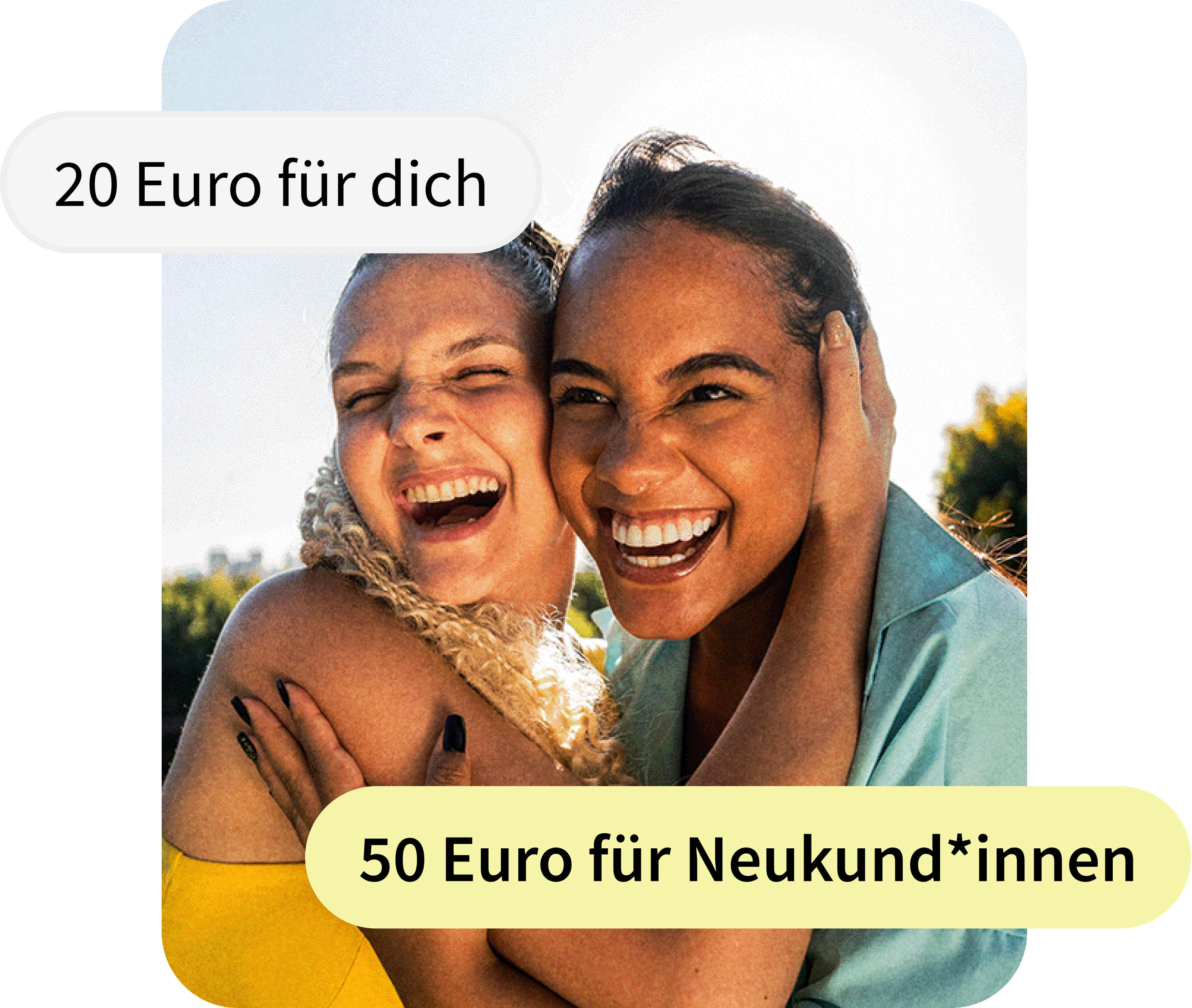 Zwei junge Frauen lachen herzlich und umarmen sich eng an einem sonnigen Tag im Freien. Sie schauen direkt in die Kamera, strahlen Freude aus und halten sich gegenseitig an den Gesichtern fest. Im Hintergrund sind Bäume und blauer Himmel zu sehen.
