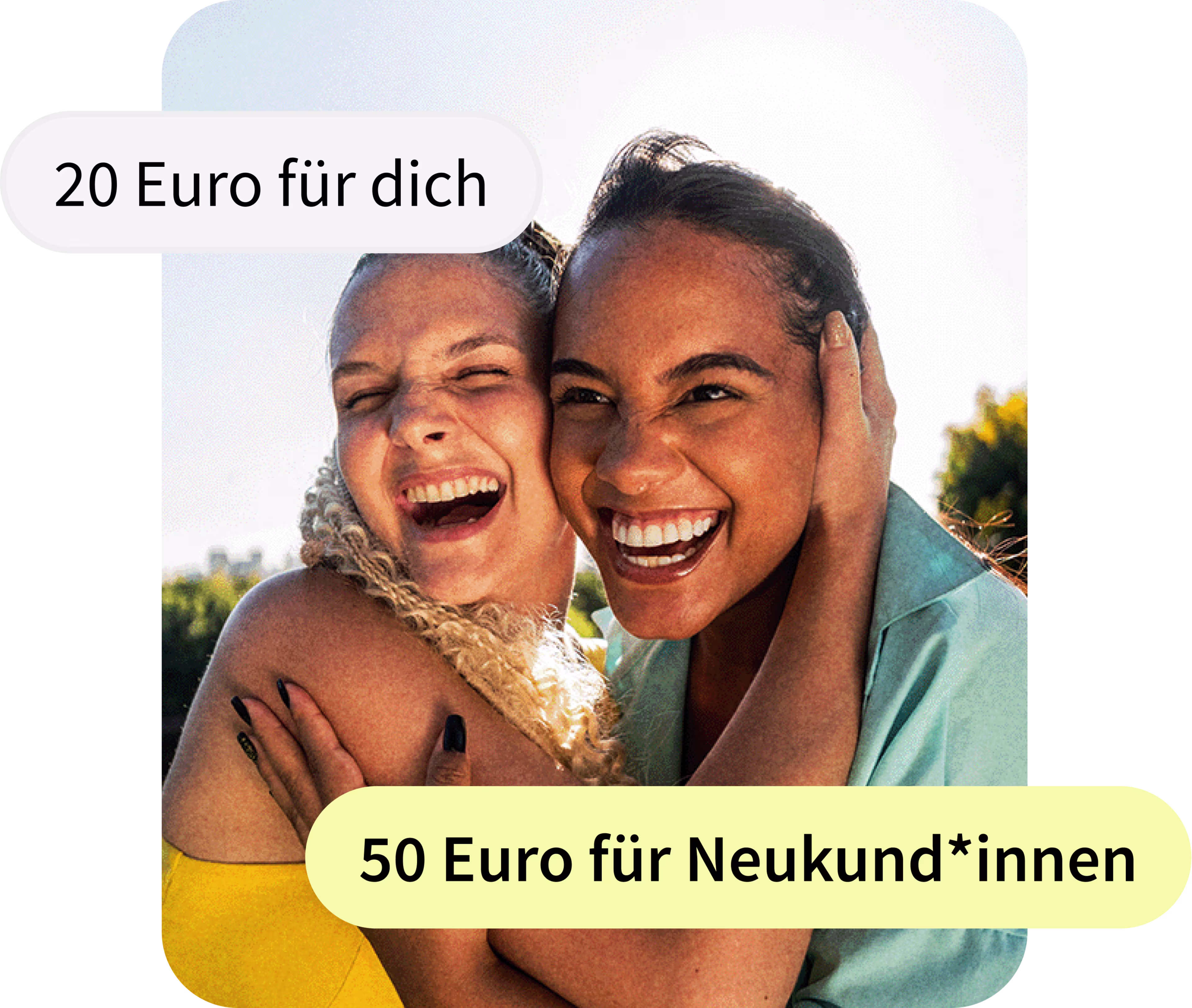 Zwei junge Frauen lachen herzlich und umarmen sich eng an einem sonnigen Tag im Freien. Sie schauen direkt in die Kamera, strahlen Freude aus und halten sich gegenseitig an den Gesichtern fest. Im Hintergrund sind Bäume und blauer Himmel zu sehen.