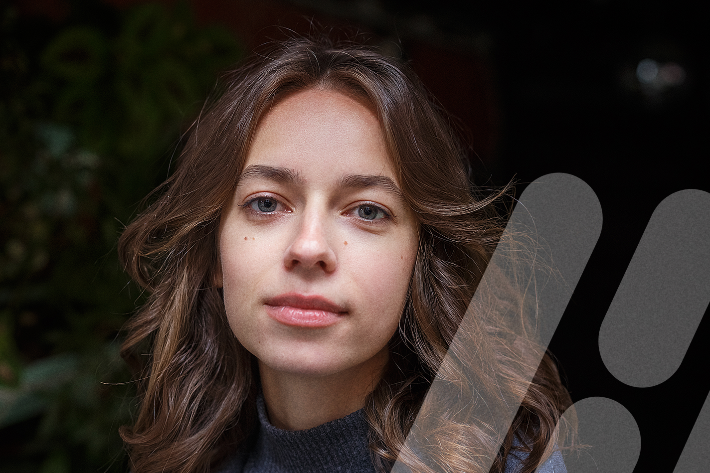 Junge Frau schaut selbstbewusst in die Kamera