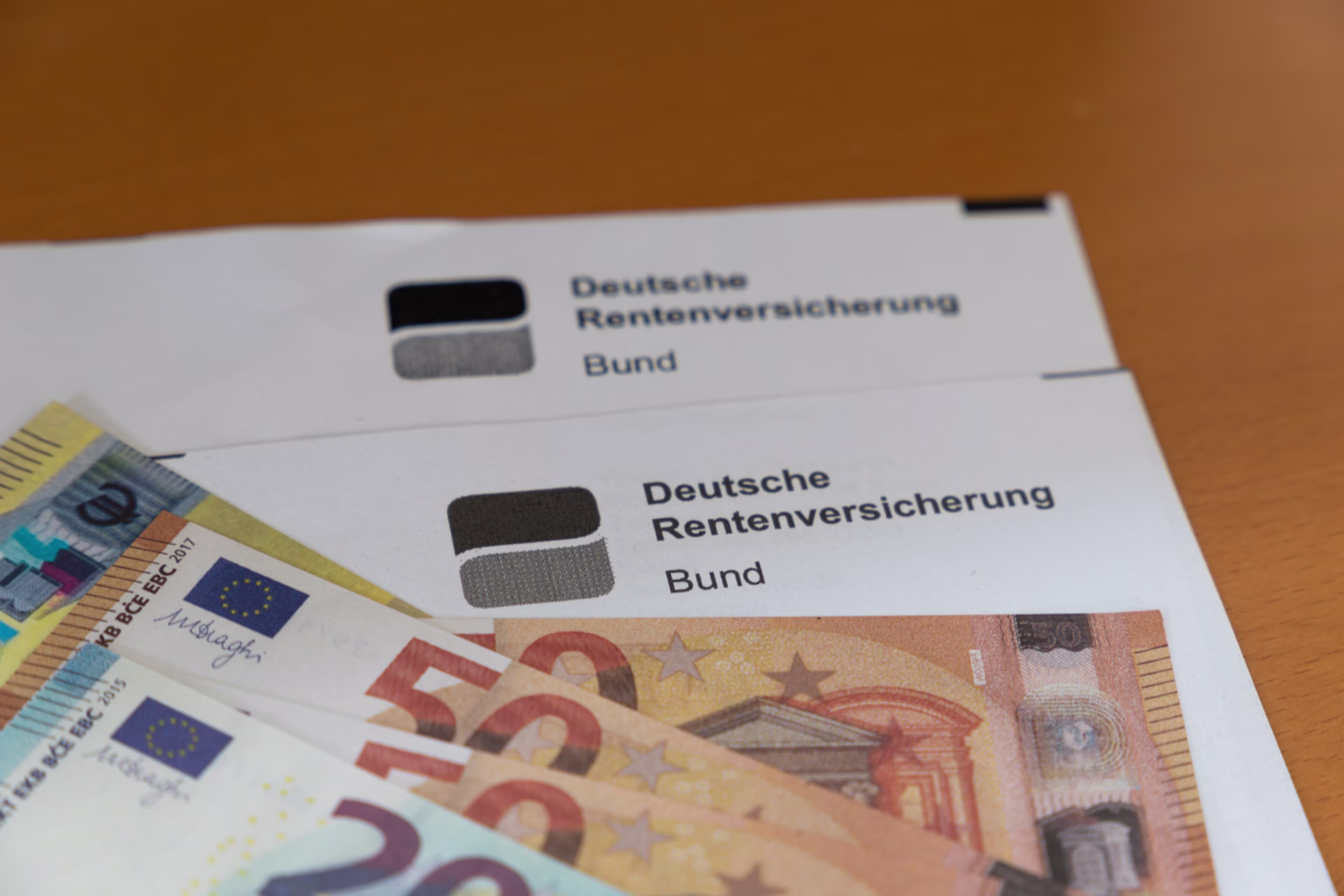 Rentenbescheid, auf dem verschiedene Geldscheine liegen