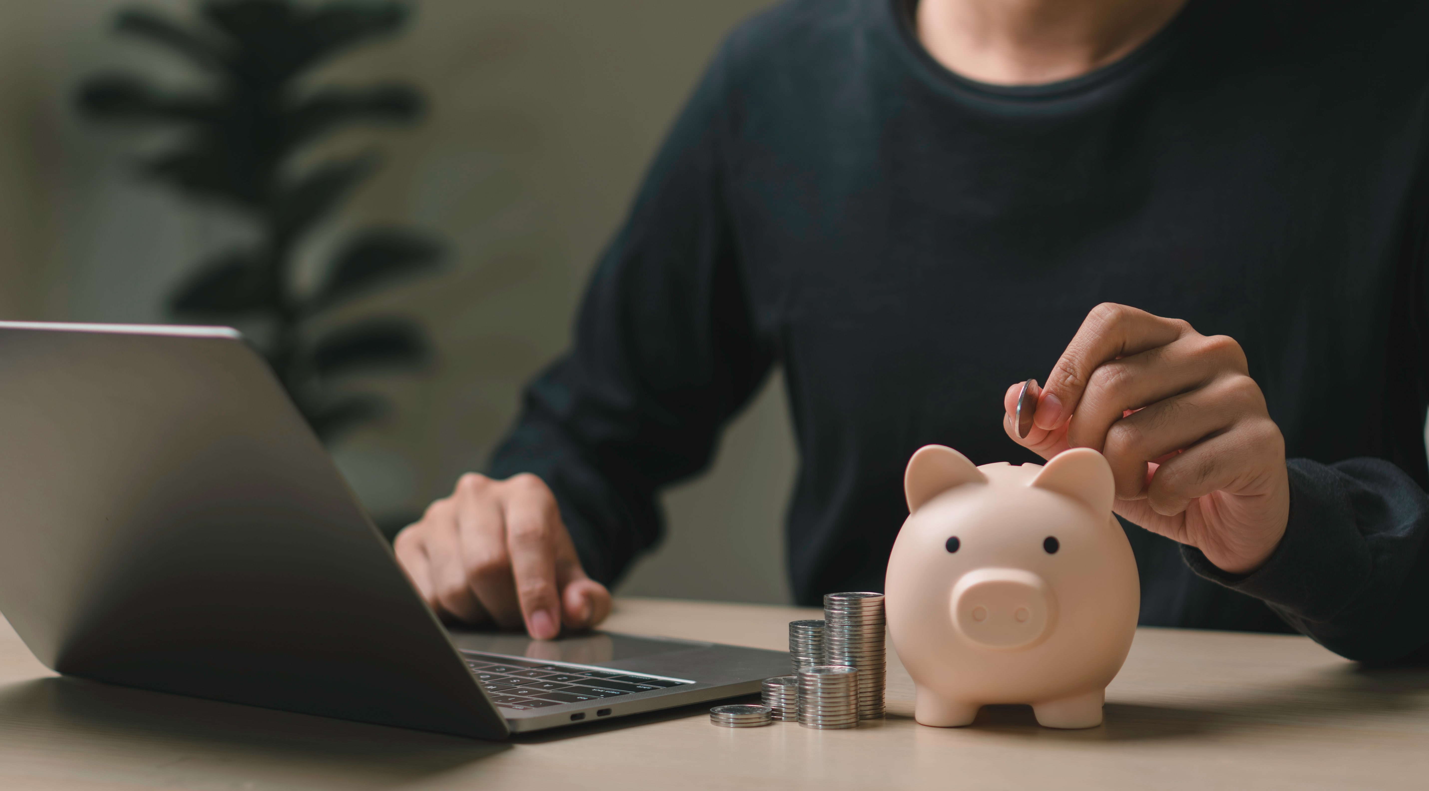 Mann wirft Münzen in eineinen Sparschwein