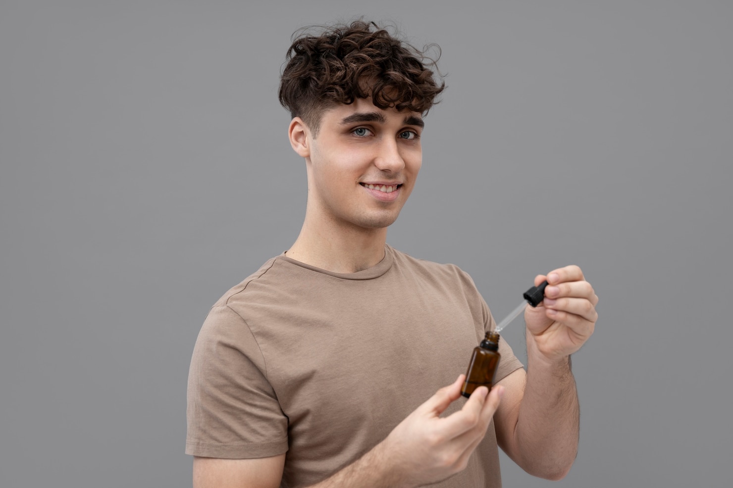 young-man-holding-serum-bottle 23-2149396126