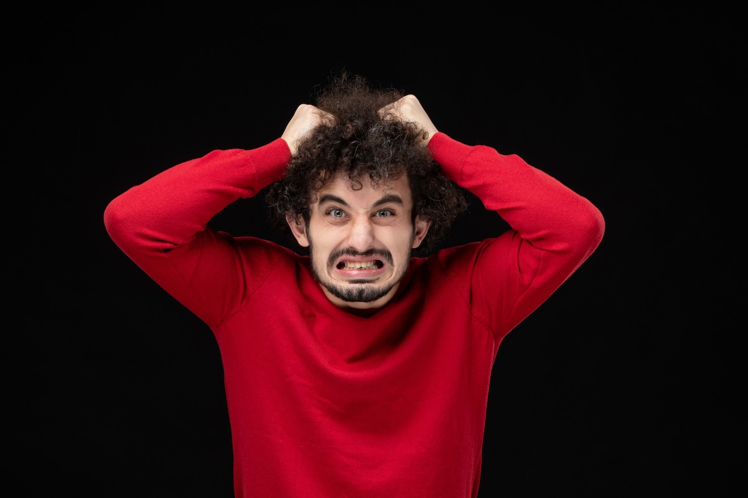 front-view-young-male-red-sweater-tearing-his-hair-black-wall 140725-143159