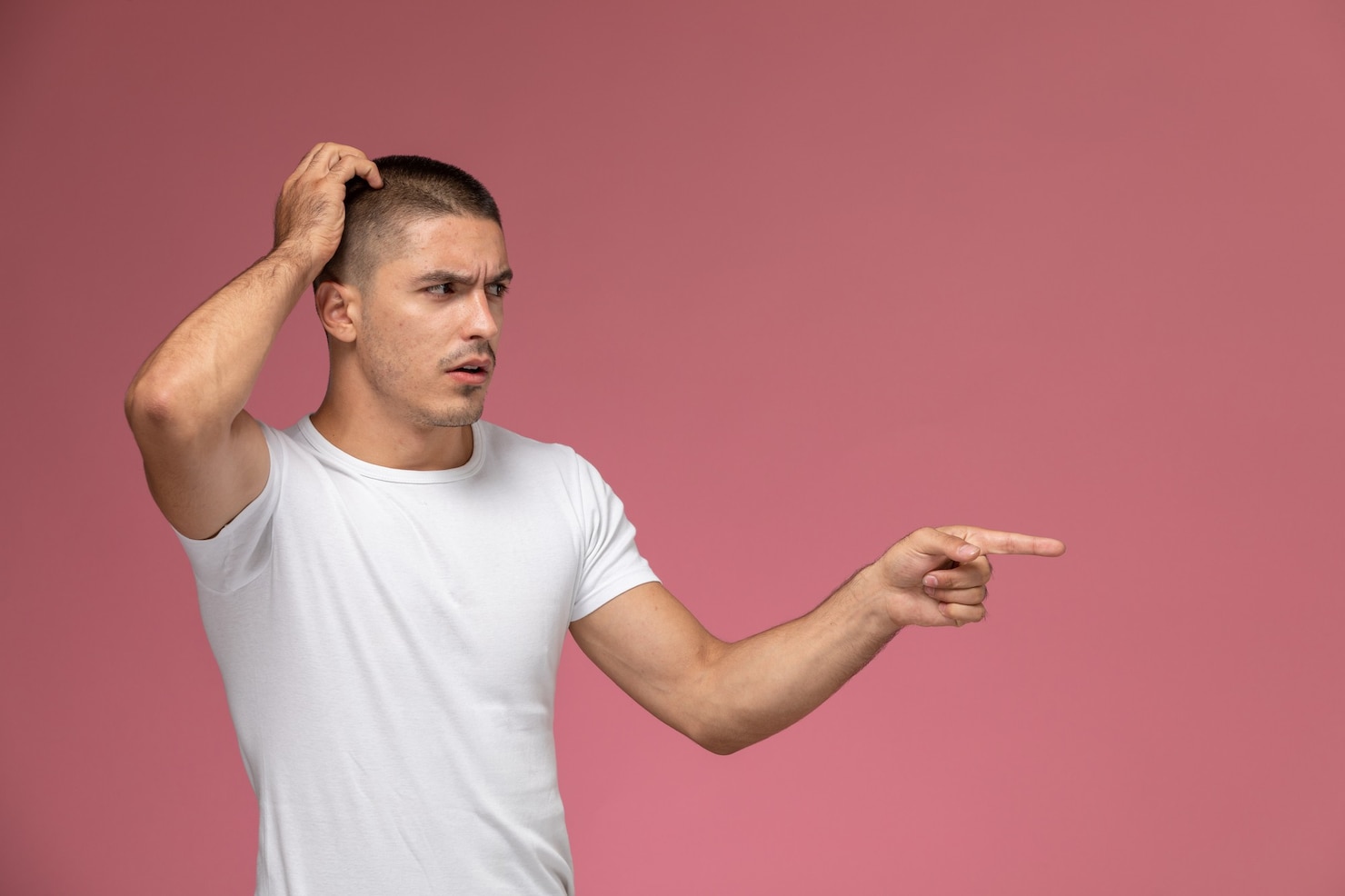 front-view-young-male-white-shirt-posing-with-confused-expression-pink-background 140725-26859