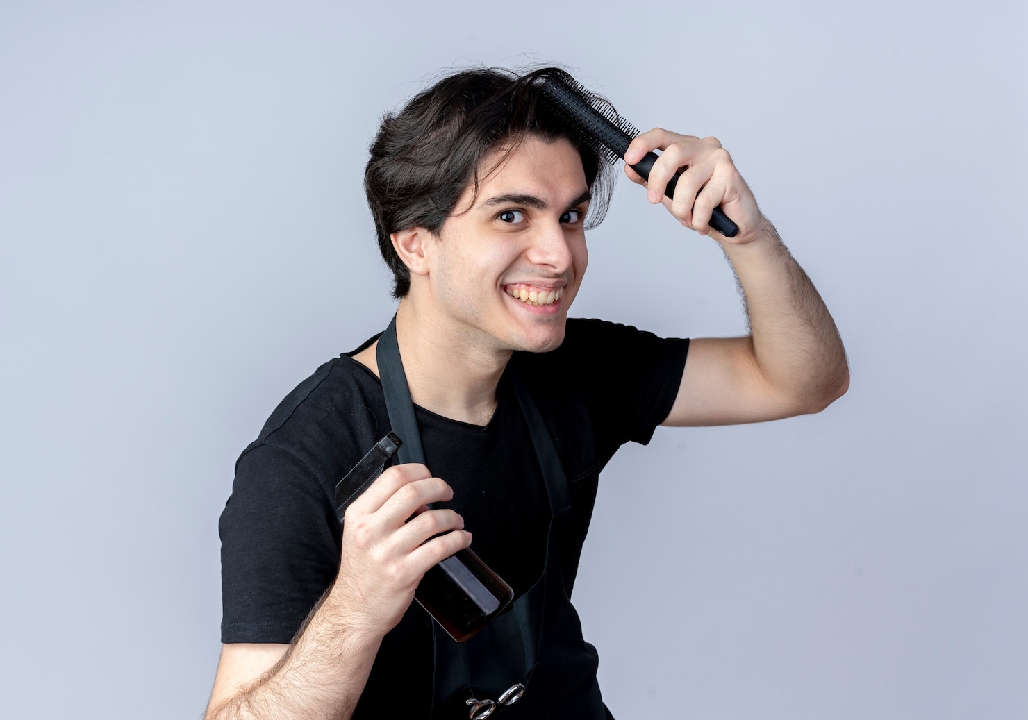 smiling-young-handsome-male-barber-uniform-combing-hair-holding-spray-bottle-isolated-white 141793-73091