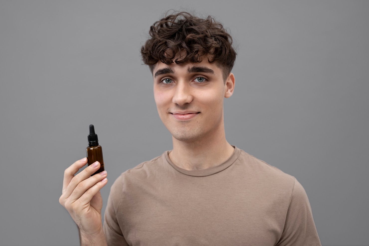 young-man-holding-serum-bottle 23-2149396124