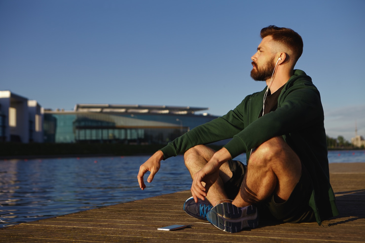 picture-attractive-unshaven-young-caucasian-guy-running-shoes-sitting-cross-legged-wooden-paving-by-lake-meditating-listening-calm-music-using-free-application-his-electronic-gadget 343059-1614