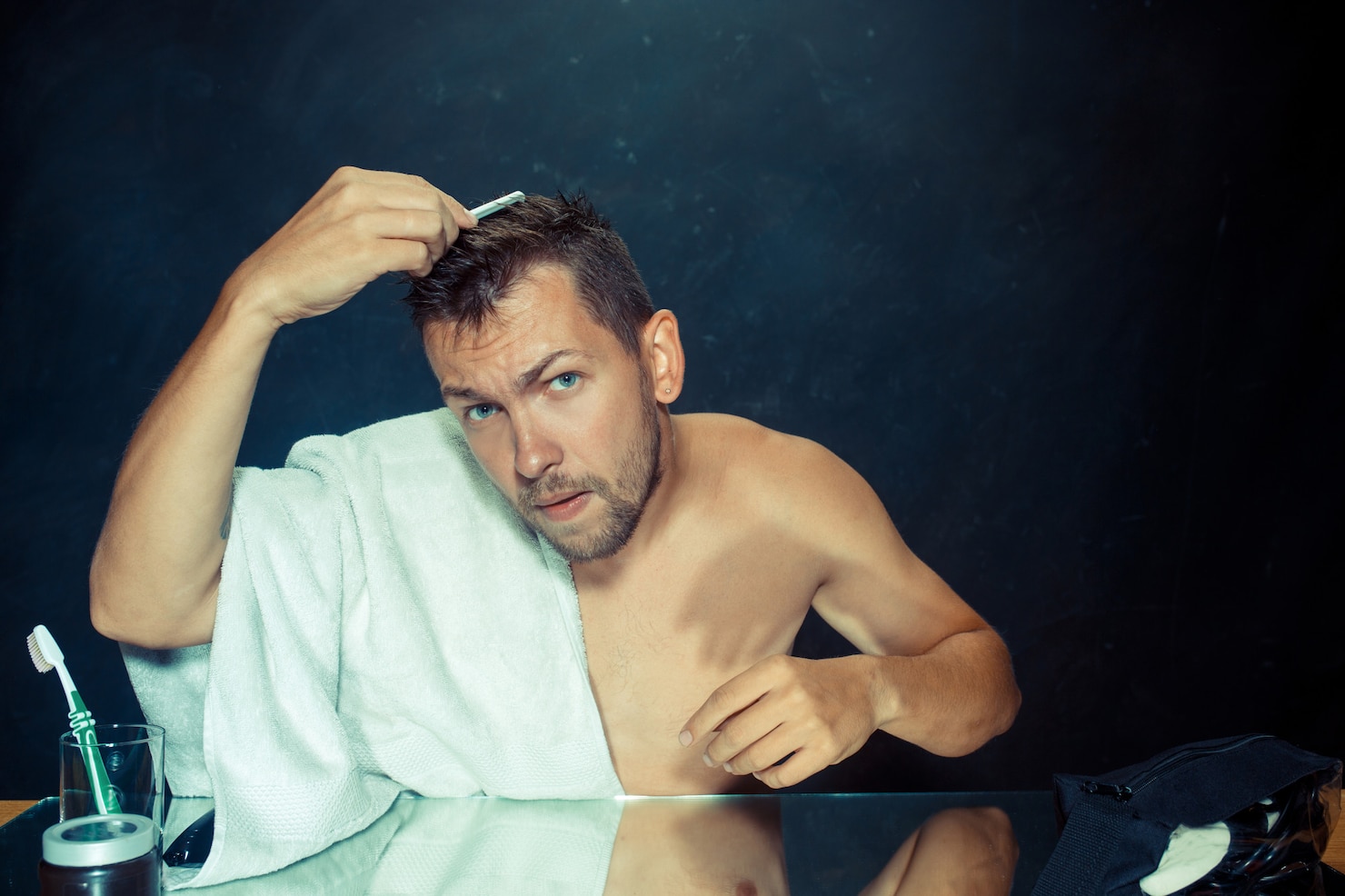 young-man-bedroom-sitting-front-mirror-scratching-his-beard 155003-3784