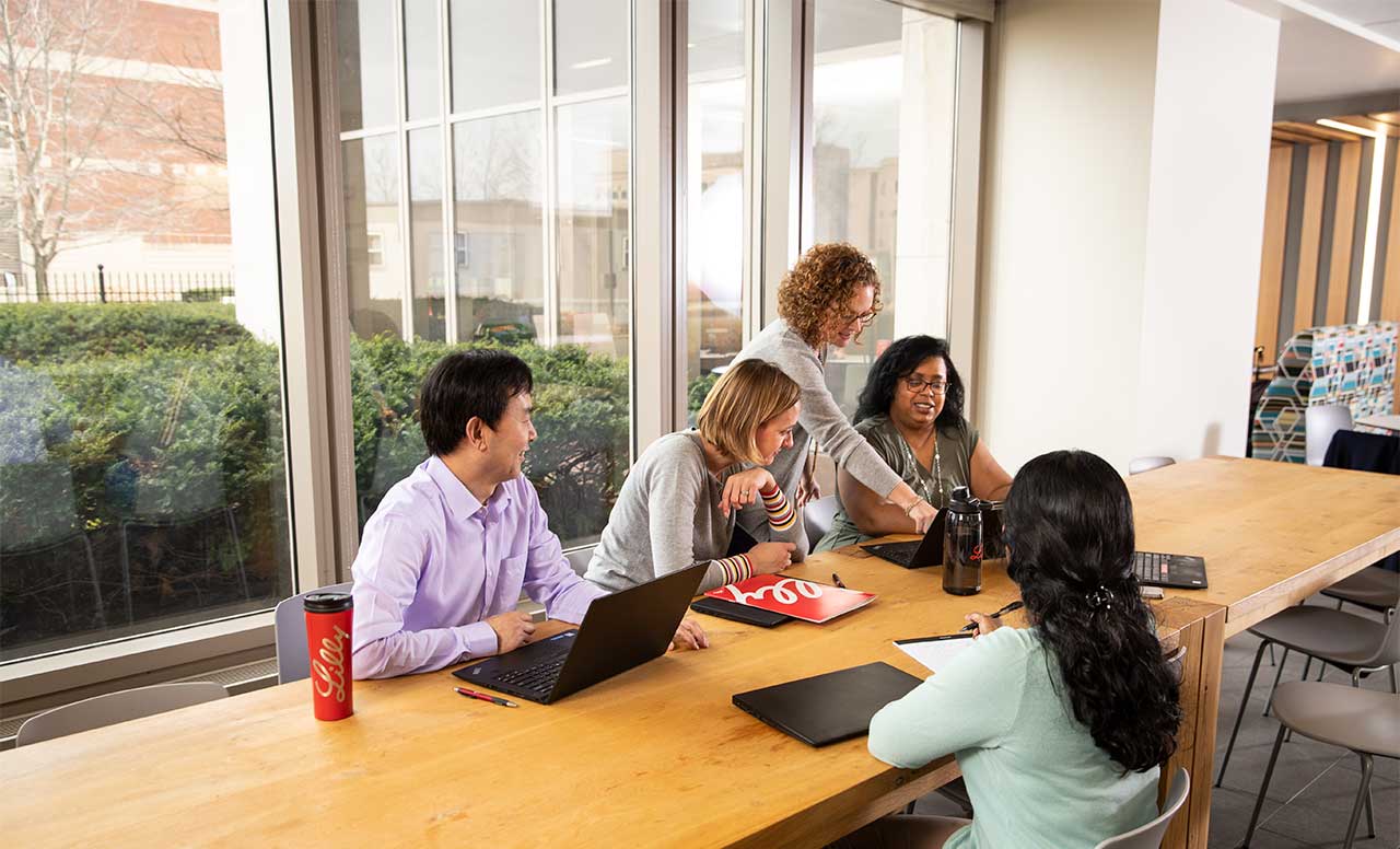 group of people working together in front of window