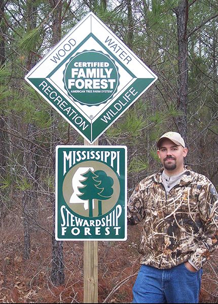 Garron Hicks (MS) with Tree Farm Sign