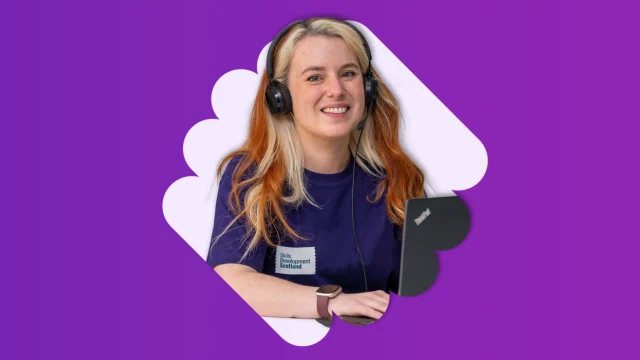 Smiling woman wearing headphones and working at laptop