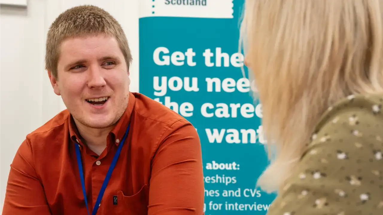 A careers adviser smiling and chatting to a customer