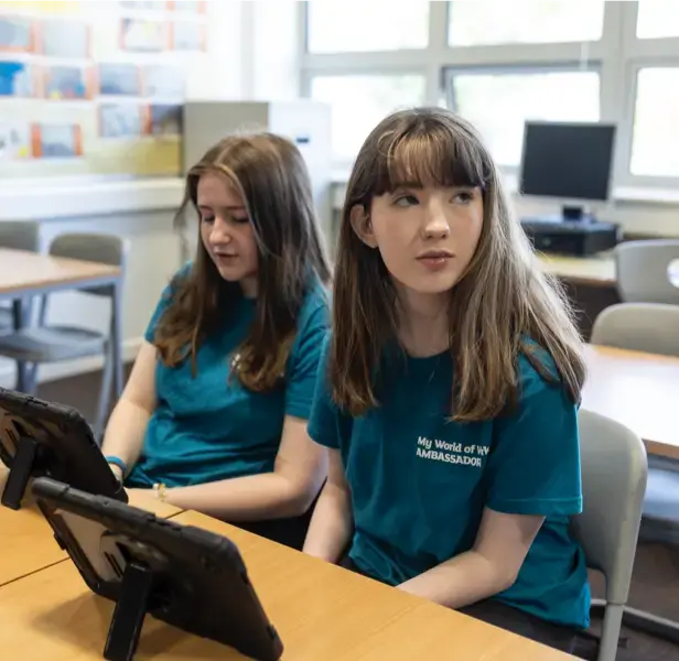 Two female school pupils wearing blue My World of Work t-shirts.