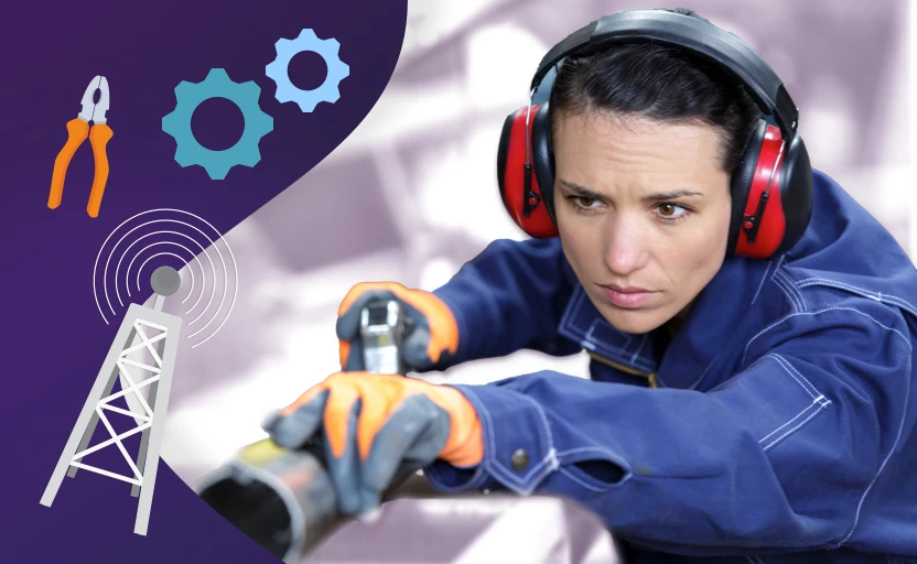 A person wearing overalls, safety gloves and ear protectors as they work with metal.