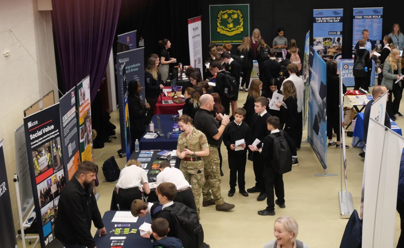 School pupils, a soldier and various other adults at a careers fayre.