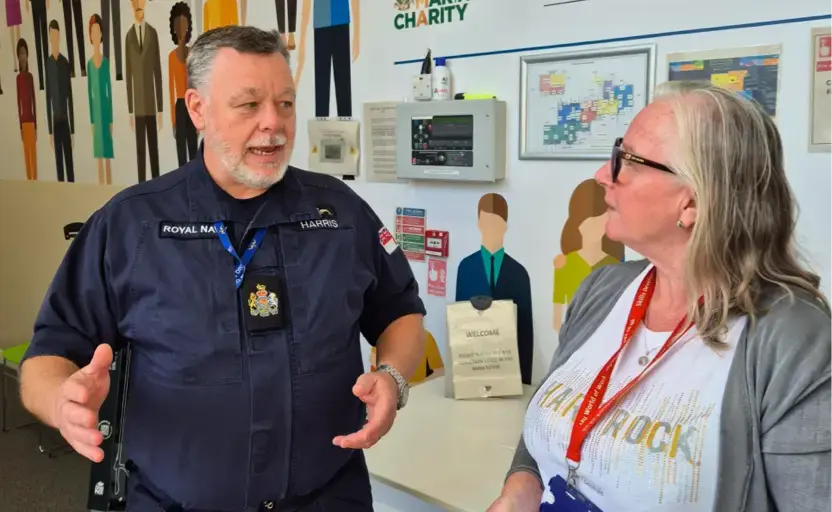 A Royal Navy officer is speaking with a careers adviser