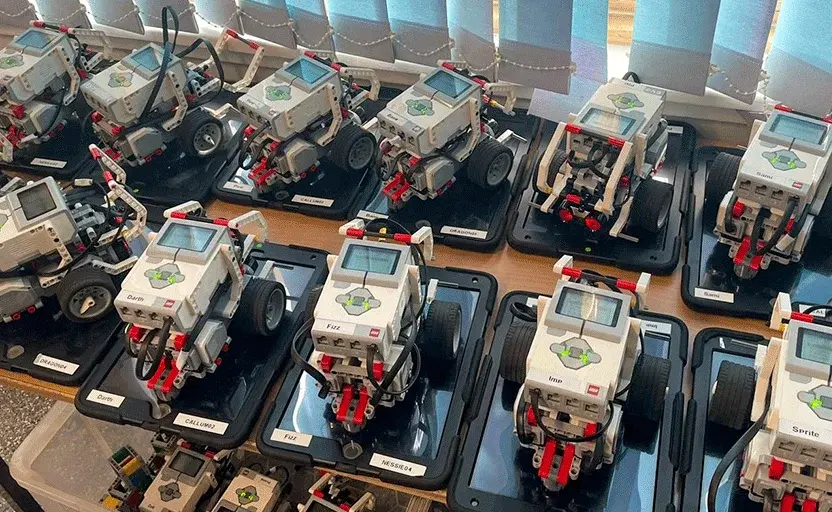 Eleven LEGO MINDSTORMS© robots sitting on a table.