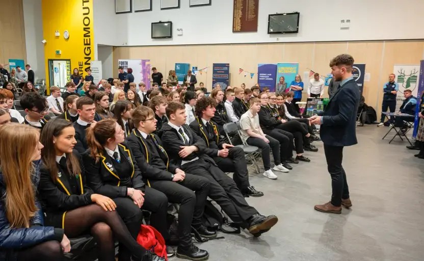 A teacher talking to a school assembly during Scottish Careers Week.