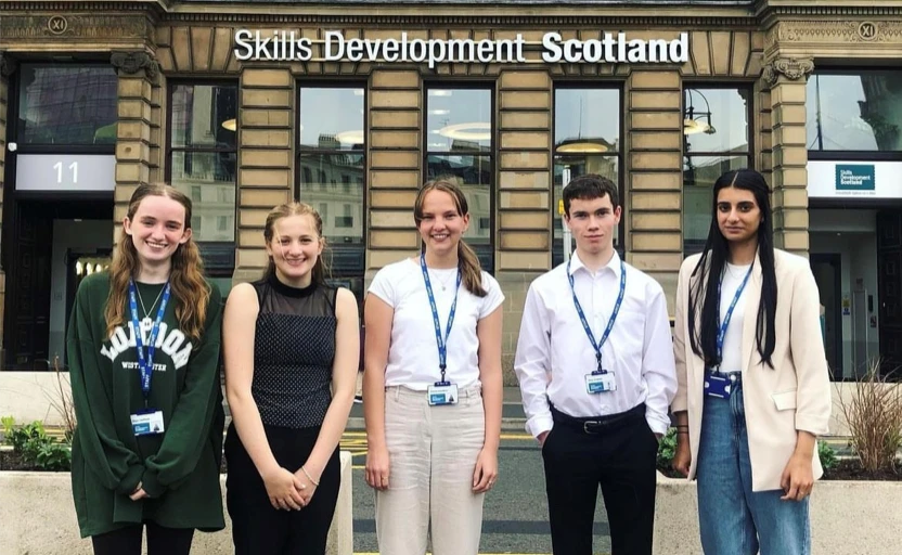 Group of Skills Development Scotland Foundation Apprentices standing with a Skills Development Scotland office behind them.