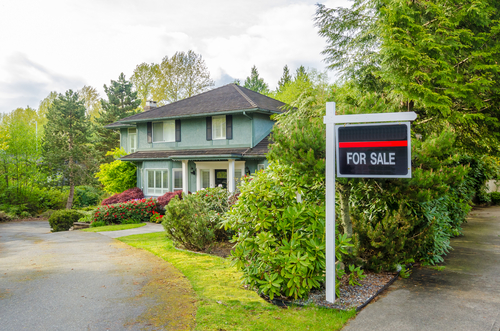 house with real estate sign
