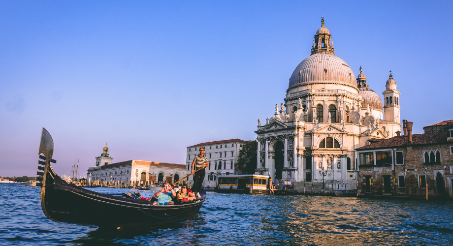 Persone su una gondola ammirano le bellezze di Venezia.