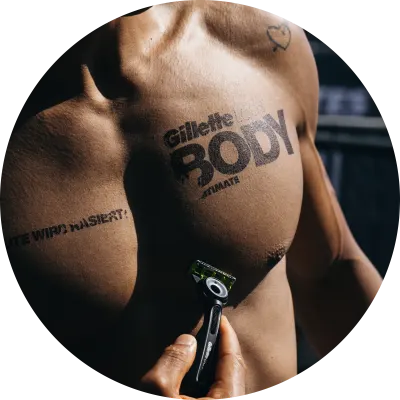 Nackter Männeroberkörper mit GilletteLabs BODY+ INTIMATE Body Tattoo und dem Gillette GilletteLabs BODY+ INTIMATE Rasierer.