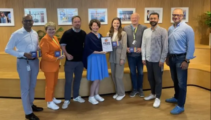 Gruppenfoto von stehenden und lächelnden Leuten