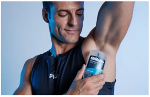Ein Mann trägt das Gillette Clear Gel Antitranspirant unter dem Arm auf und demonstriert den transparenten Schutz vor Schweiß und Geruch.