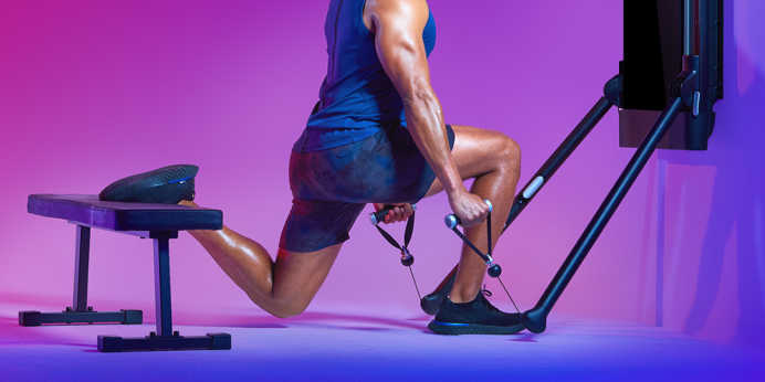 Side view of athletic man exercising with a Tonal machine.