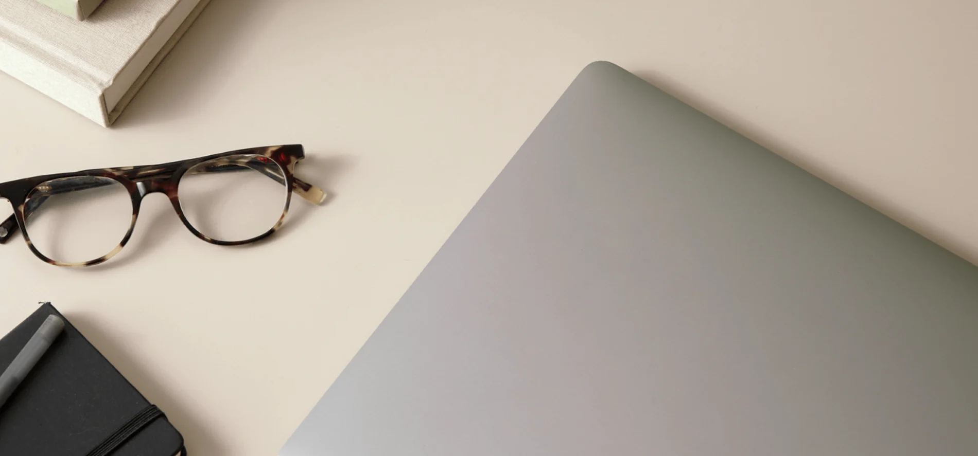 Image of a silver laptop with leopard print glasses on a desk