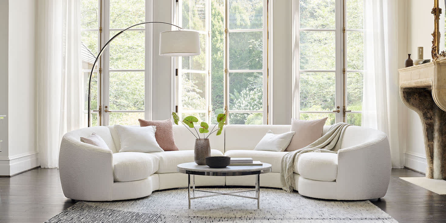 Living room showcase, bright oudoor setting in the background, from MG+BW Home Furnishings. A sectional sofa is front and center.