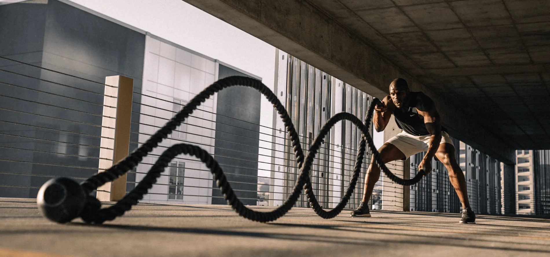 Image of a person exercising with conditioning ropes in a city loft