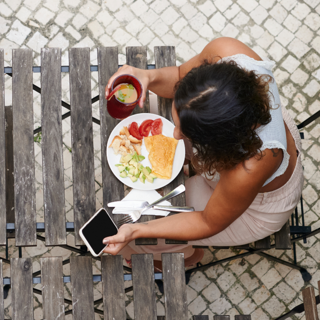 Person eating food while looking at their phone
