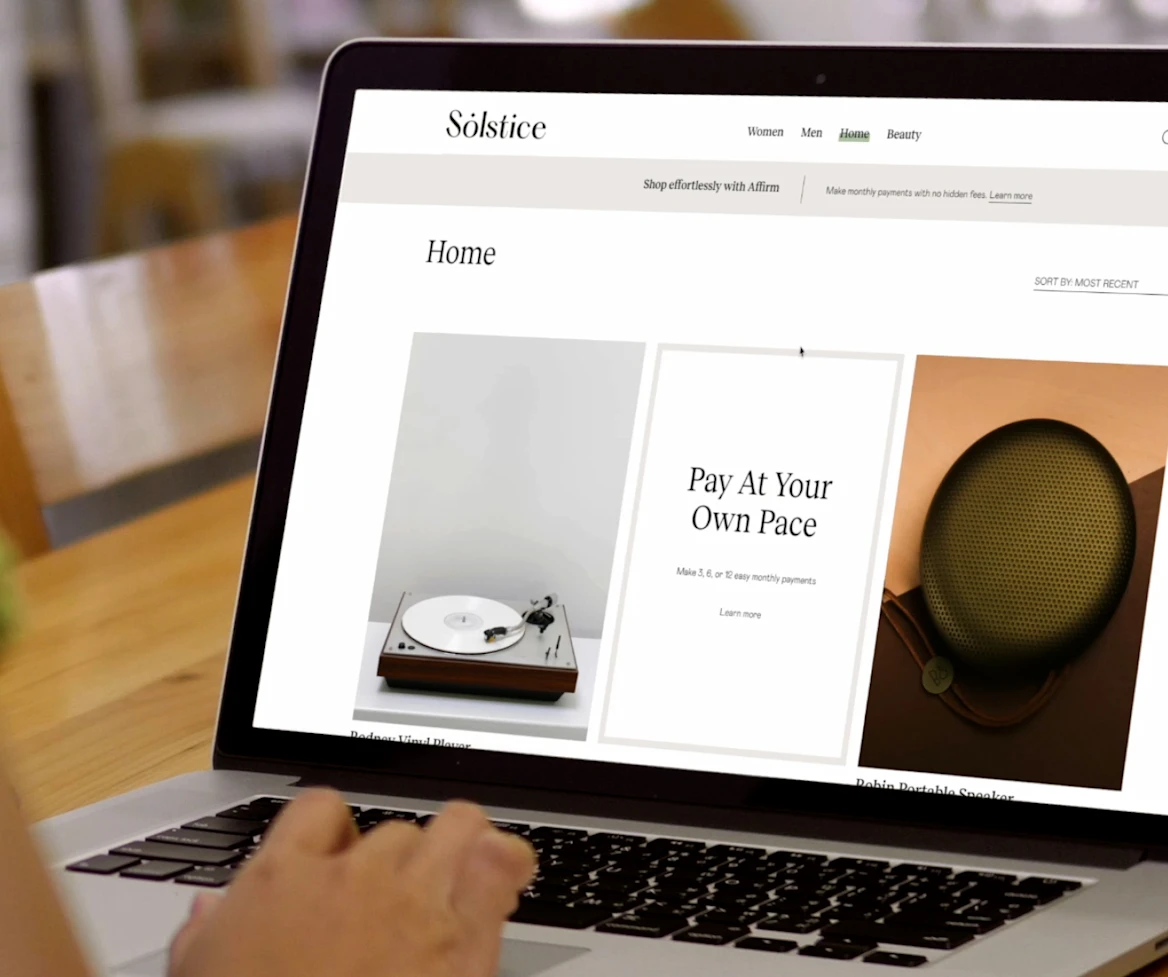 image of person scrolling on laptop on a wooden table